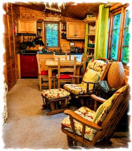a living room with a table and chairs and a kitchen at Blelham Tarn Rustic cabin in tranquil woodland in Ambleside