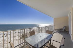 a balcony with a table and chairs on the beach at San Carlos Unit 607 in Gulf Shores