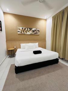a bedroom with a large white bed in a room at The Dhania Cenang Beach Langkawi in Pantai Cenang