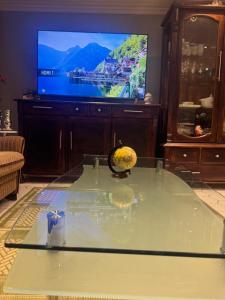 a living room with a glass table and a tv at Basement Apartment Varadero in Lyngdal