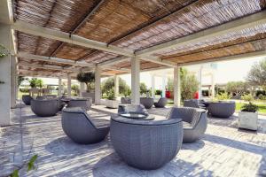 a patio with chairs and tables under a pergola at Velipoja Grand Europa Resort, Affiliated by Meliá in Velipojë