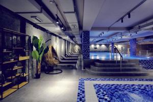 a swimming pool in a building with stairs and a swimming pool at Velipoja Grand Europa Resort, Affiliated by Meliá in Velipojë