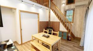a room with a wooden table and a staircase at Daruma in Nasu