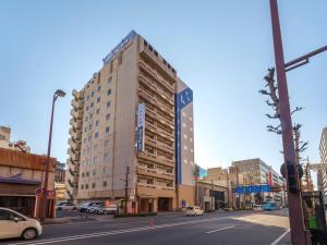 a tall building on a city street with a street at Dormy Inn Takamatsu in Takamatsu +70 photos