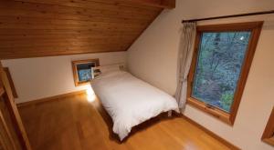 a bedroom with a bed in a room with a window at Daruma in Nasu
