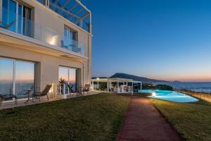 a building with a view of the ocean at night at Bellevue Sardinia Resort, Affiliated by Meliá in Valledoria