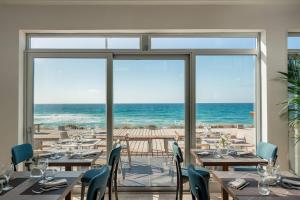 a restaurant with a view of the ocean at Bellevue Sardinia Resort, Affiliated by Meliá in Valledoria