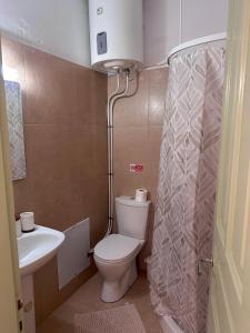 a small bathroom with a toilet and a sink at Stone Steps Studio in Symi +14 photos