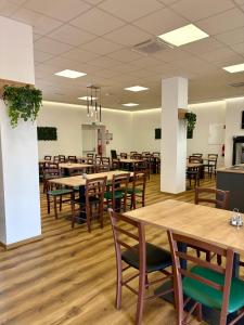 ein Esszimmer mit Holztischen und Stühlen in der Unterkunft Ambient Hotel in Domžale