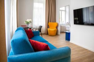 a blue couch with red pillows in a living room at Aparthotel František in Světlá nad Sázavou