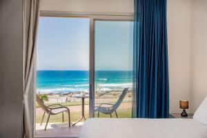 a bedroom with a bed and a view of the ocean at Bellevue Sardinia Resort, Affiliated by Meliá in Valledoria
