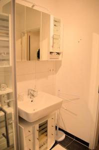 a white bathroom with a sink and a mirror at Ferienwohnung Nitsche in Bad Laasphe