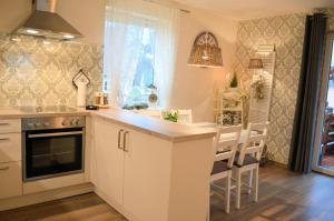 a kitchen with white cabinets and a table and chairs at Ferienwohnung Nitsche in Bad Laasphe