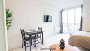a bedroom with a table and chairs and a bed at La Villette - Charming flat in Pantin - GetHosted in Pantin