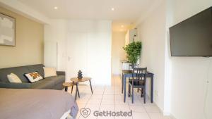 a room with a bed and a couch and a tv at La Villette - Charming flat in Pantin - GetHosted in Pantin