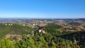 a house on top of a hill with trees at La Cascinassa in Tagliolo Monferrato