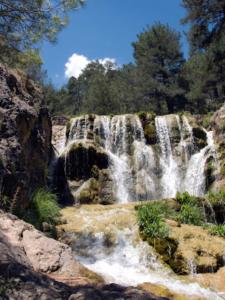 a large waterfall in the middle of a forest at Hostal Avenida Pozo Alcón in Pozo Alcón