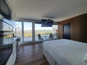 a hotel room with a bed and a large window at CASA OURO D'ALVA - Luxury Lodging, SPA & WELLNESS in Penalva do Castelo