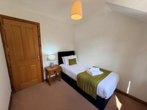 a small bedroom with a bed and a door at The Galleries No 2 in Spean Bridge
