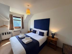 a bedroom with a large bed with a blue headboard at The Galleries No 2 in Spean Bridge