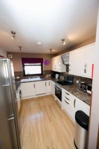 a kitchen with white cabinets and a large window at The Galleries No 2 in Spean Bridge