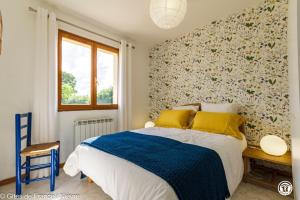 a bedroom with a bed with yellow and blue sheets at Le Clos in Anthien