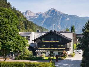 a building with a mountain in the background at Natürlich Hell - Camping & Aparthotel in Fügen