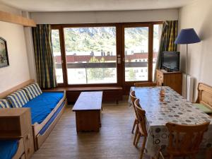 a small room with a bed and a table and a couch at Le Bec Rouge in Tignes