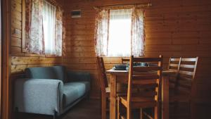 a living room with a couch and a table and a window at Domki Letniskowe Krakus in Rusinowo