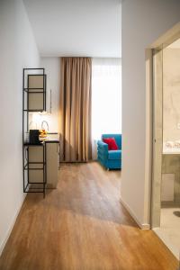 a living room with a blue couch and a window at Aparthotel František in Světlá nad Sázavou