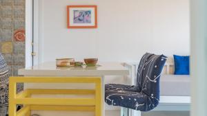 a dining room table with a yellow chair next to it at Yangyang Monti Pet Spa Pension in Yangyang
