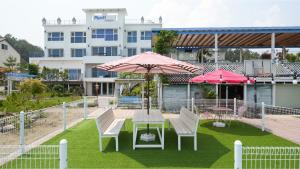 a patio with a table and two chairs and umbrellas at Yangyang Monti Pet Spa Pension in Yangyang