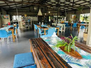 a restaurant with tables and chairs and a wooden bench at Emoyeni Eco Lodge in Sodwana Bay