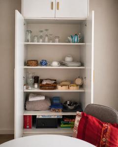 a white pantry with food and dishes in it at Les Mésanges Bleu in Malmedy