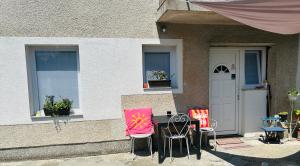 two chairs and a table in front of a house at Apartment In Time in Sesvete