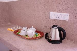 a tea set on a plate on a kitchen counter at Residenza Belvedere in Hikkaduwa