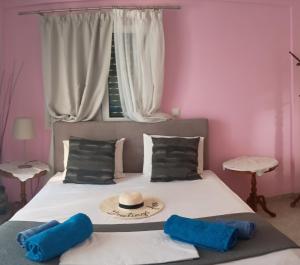 ein Schlafzimmer mit einem Bett, einer Mütze und zwei Kissen in der Unterkunft Trizinia view balcony in Galatás