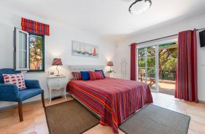 a bedroom with a bed and a chair and a window at Villa Praia Verde - Beach & Nature in Praia Verde +29 photos