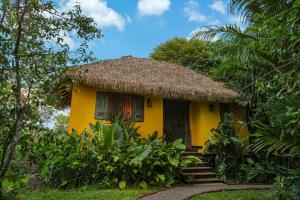 a small yellow house with a straw roof at Huma Terra Lodges in Hikkaduwa