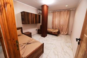 a small room with two beds and a mirror at Hostel Bouchair Centre Ville Jijel in Jijel