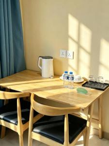 a wooden table with two chairs and water bottles on it at zhiyuanta hotel in Vientiane