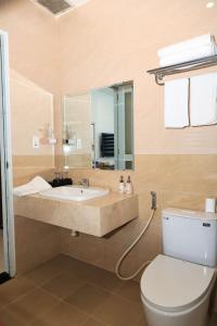 a bathroom with a sink and a toilet and a mirror at Lucky Hotel in Phước Lai +32 photos