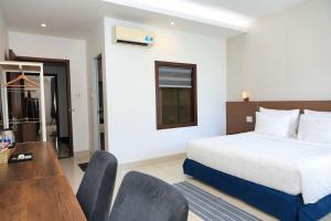 a hotel room with a bed and a desk and chairs at Lucky Hotel in Phước Lai