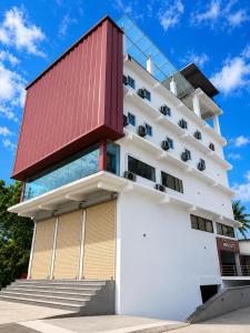 ein großes weißes Gebäude mit rotem Dach in der Unterkunft Hotel Miralite in Tinsukia
