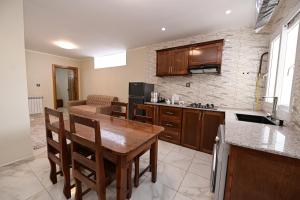 a kitchen with a table and chairs and a couch at Hostel Bouchair Centre Ville Jijel in Jijel