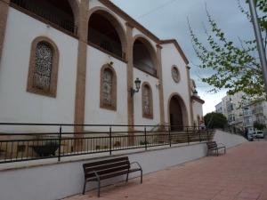 a church with two benches in front of it at Hostal Avenida Pozo Alcón in Pozo Alcón