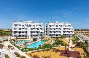 a large white apartment building with a swimming pool at Casa Feliz - Santa Rosalia Life and Lake Resort in Torre-Pacheco