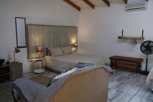 a bedroom with a bed and a couch in it at Numbi Hills Self-Catering in Hazyview +43 photos