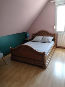 a bedroom with a large bed with a wooden floor at Bugatti 4 chambres- 4 lits doubles in Teloché