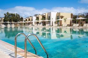 a large swimming pool with chairs and umbrellas at Zephyr Saidia in Saïdia +5 photos